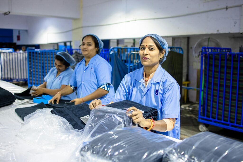 Indian female workers in a textile factory, folding fabrics with focus and teamwork.